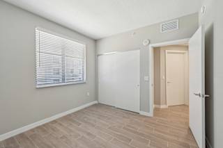 A room with a white door and a window with blinds.