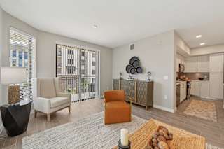 A living room with a sofa, chairs, and a rug.