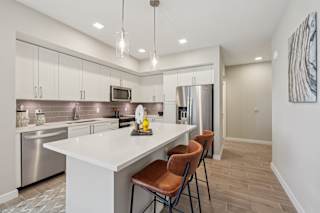A modern kitchen with a white island and stainless steel appliances.