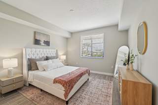 A bedroom with a large bed and a wooden dresser.