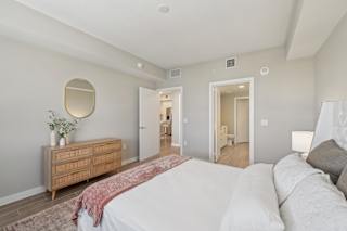 A bedroom with a bed, dresser, and mirror.