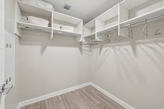A white closet with shelves and hangers.