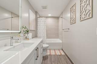 A bathroom with a white sink and a white toilet.