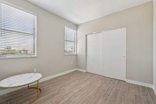 A room with a white table and a white closet.