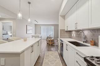 A modern kitchen with white cabinets and a large island.