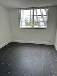 A room with a window and tiled flooring.