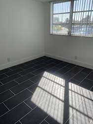 A room with a window and sunlight shining through.