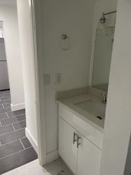 A white bathroom with a sink and mirror.