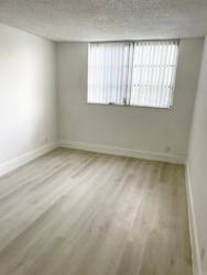 A room with a window and wooden flooring.