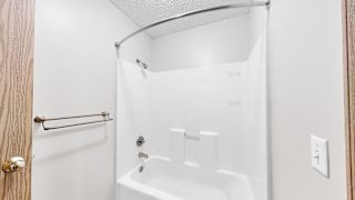 A white bathroom with a tub and shower.