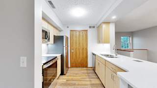 A kitchen with wooden floors and white countertops.