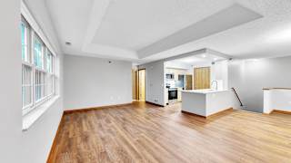 A spacious room with wooden floors and white walls.