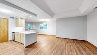 A kitchen with wooden floors and white walls.