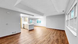 A spacious room with wooden floors and white walls.