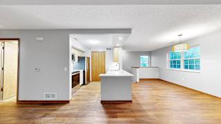 A kitchen with a white counter and wooden floors.