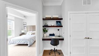 A bedroom with a bed, desk, and chair.