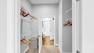 A hallway with a white door and a carpeted floor.