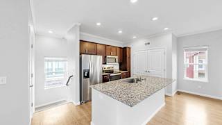 A kitchen with a granite countertop and a refrigerator with a water dispenser.