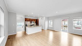 A large open living space with a kitchen in the background.