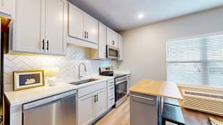 A modern kitchen with white cabinets and stainless steel appliances.