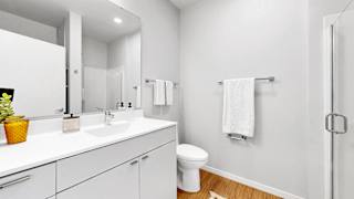 A white bathroom with a toilet, sink, and mirror.
