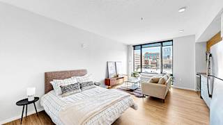 A bedroom with a large bed and a view of the city.