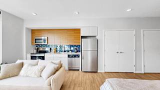 A modern kitchen with a white couch and wooden accents.
