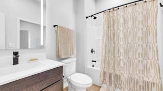 A bathroom with a toilet, sink, and shower curtain.