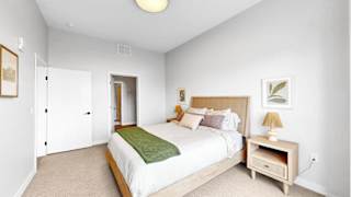 A bedroom with a bed, nightstand, and lamp.