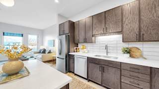 A modern kitchen with wooden cabinets and a white countertop.