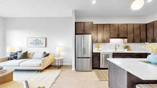 A modern kitchen with a refrigerator, sink, and cabinets.
