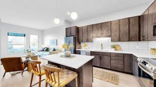 A modern kitchen with wooden cabinets and a white island.