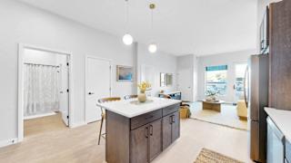 A modern kitchen with a white island and wooden cabinets.