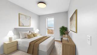 A bedroom with a large bed and a window overlooking a beach.