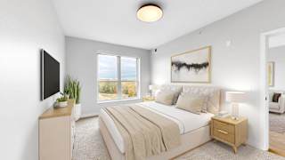 A bedroom with a large bed, a flat screen TV, and a window overlooking the ocean.