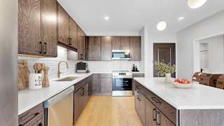 A modern kitchen with wooden cabinets and a white countertop.
