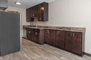 a kitchen with wooden cabinets and a stainless steel refrigerator