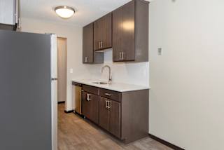 a kitchen with dark wood cabinets and a white counter top