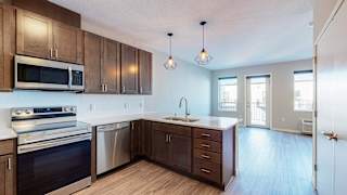 a kitchen with dark wood cabinets and white countertops at The Morrison, Minnesota