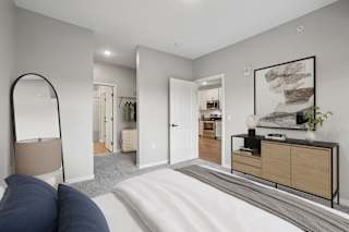 A bedroom with a large bed and a mirror on the wall.