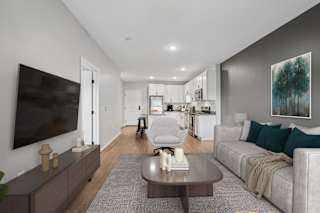 A modern living room with a grey couch and a coffee table.