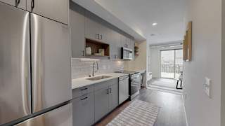 A modern kitchen with stainless steel appliances and white cabinetry.at Tyler Street Stacks, Minneapolis, 55413