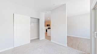 a bedroom with a medium sized bed and a doorway leading to a kitchen