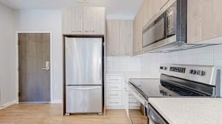 a kitchen with white cabinets and stainless steel appliances