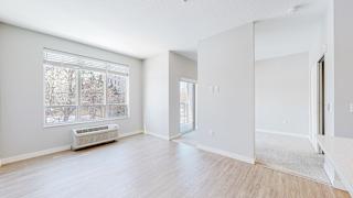 a bedroom with a large window and hardwood floors