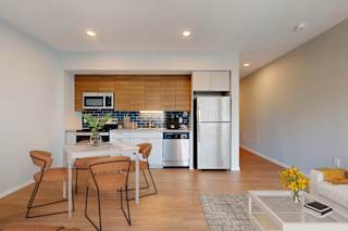 A modern kitchen with a dining table and chairs.