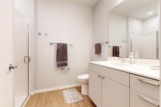 A white bathroom with a towel hanging on the towel rack.