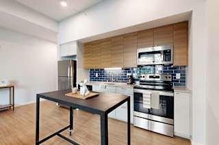 A modern kitchen with a black table and stainless steel appliances.