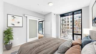 A bedroom with a large bed and a plant.