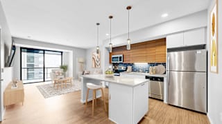 A modern kitchen with a white island and stainless steel appliances.